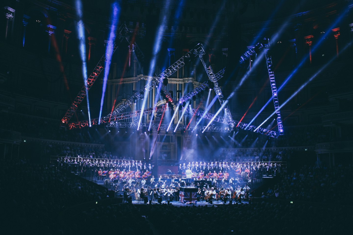 Un'orchestra e un coro si esibiscono sul palco con un direttore.